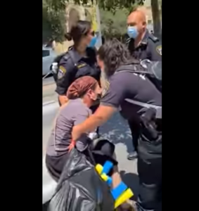 La police israélienne se débat avec une femme qui a refusé de porter un masque de protection